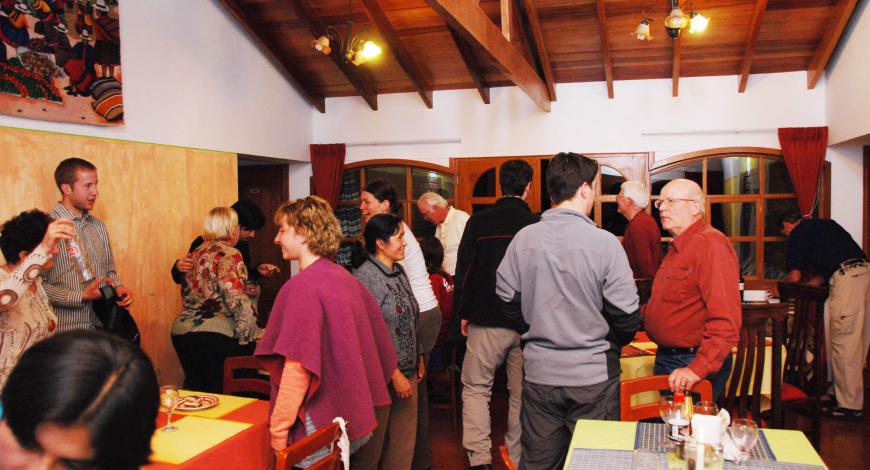 A number of people gathered in a room with tables