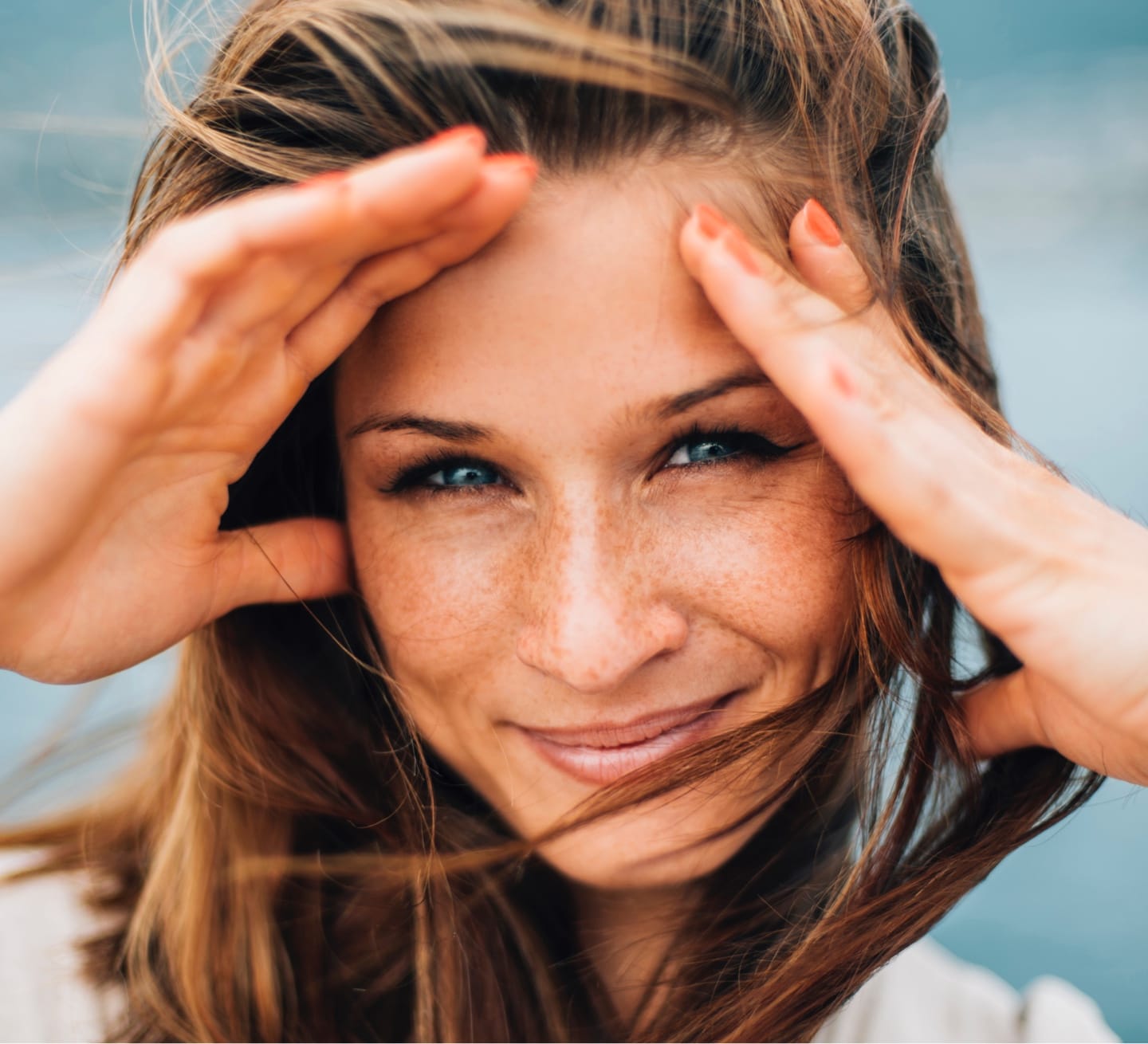 Woman's face with both hands to her forehead