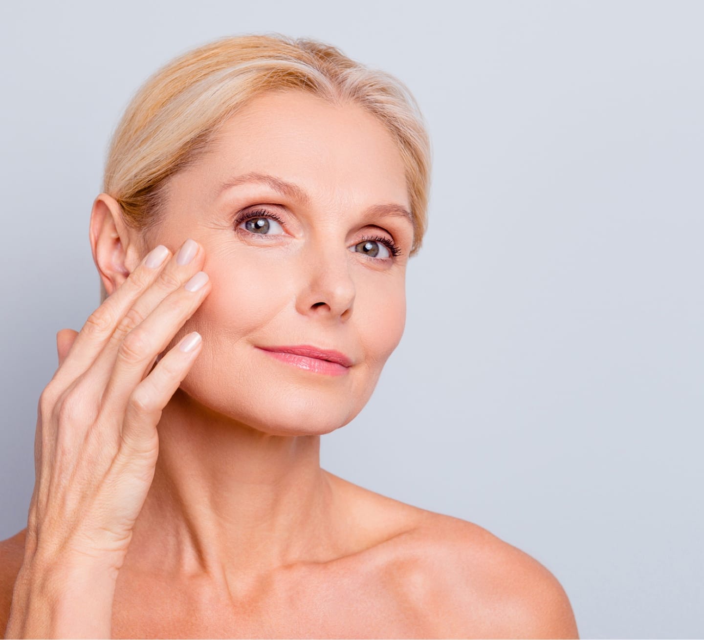 Older woman putting a hand to her face
